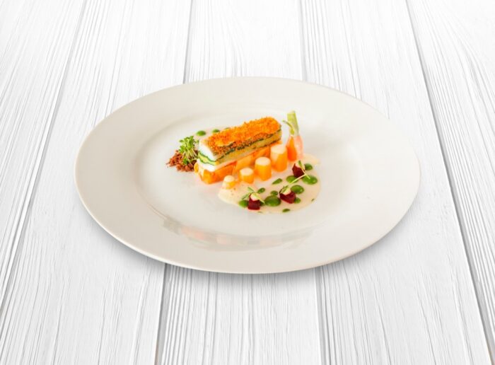 Foto receta de porcion de merluza con zanahoria sobre una cama de verduras y salsa blanca