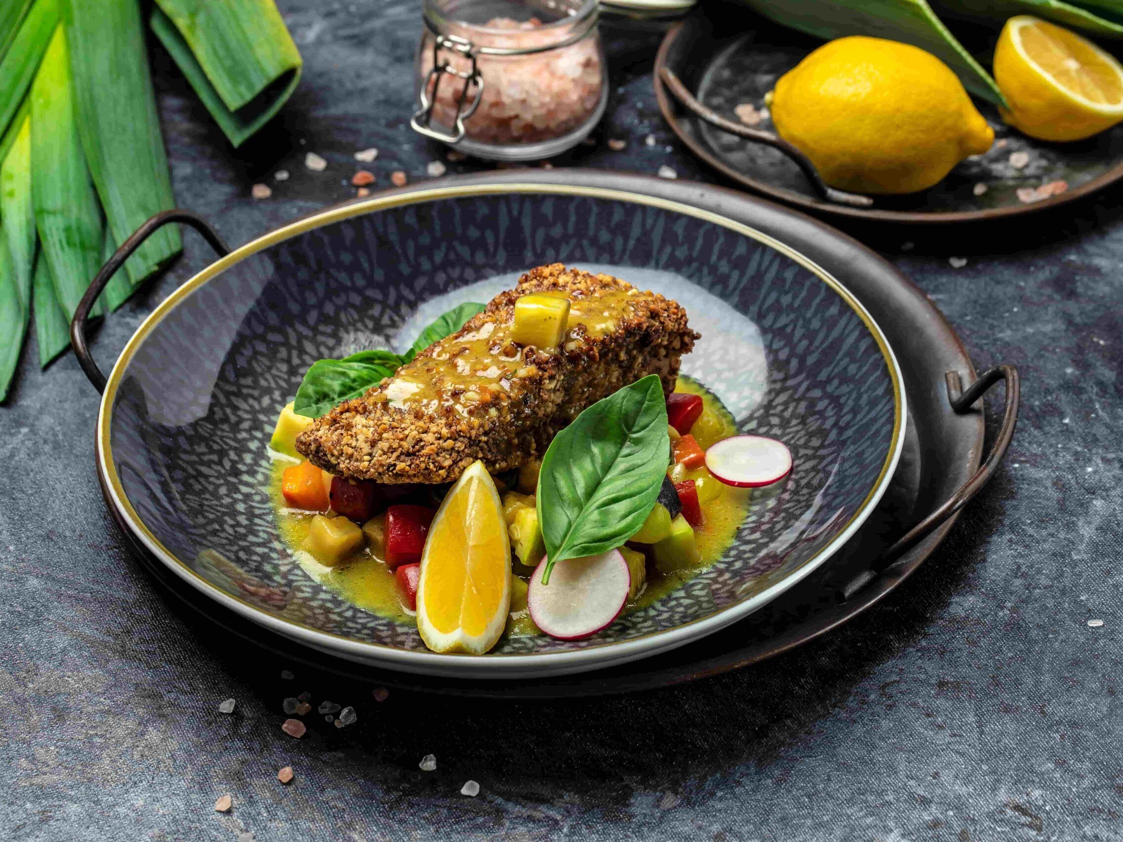 Foto receta de merluza empanada en nueces con salsa de pimienta y verduras pescanova fish solutions ladeada